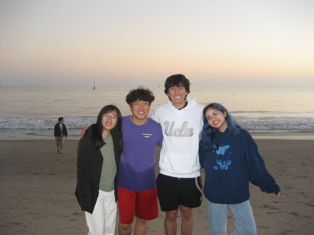 Four organizers on the beach at sunset
