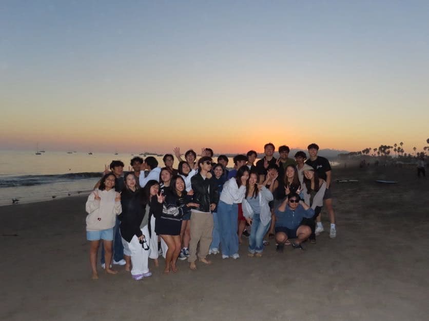 The whole organizing team on the beach at sunset
