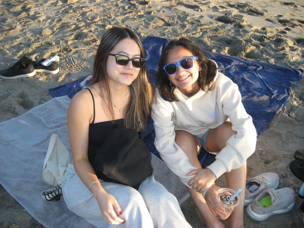 Two organizers sitting together on the beach