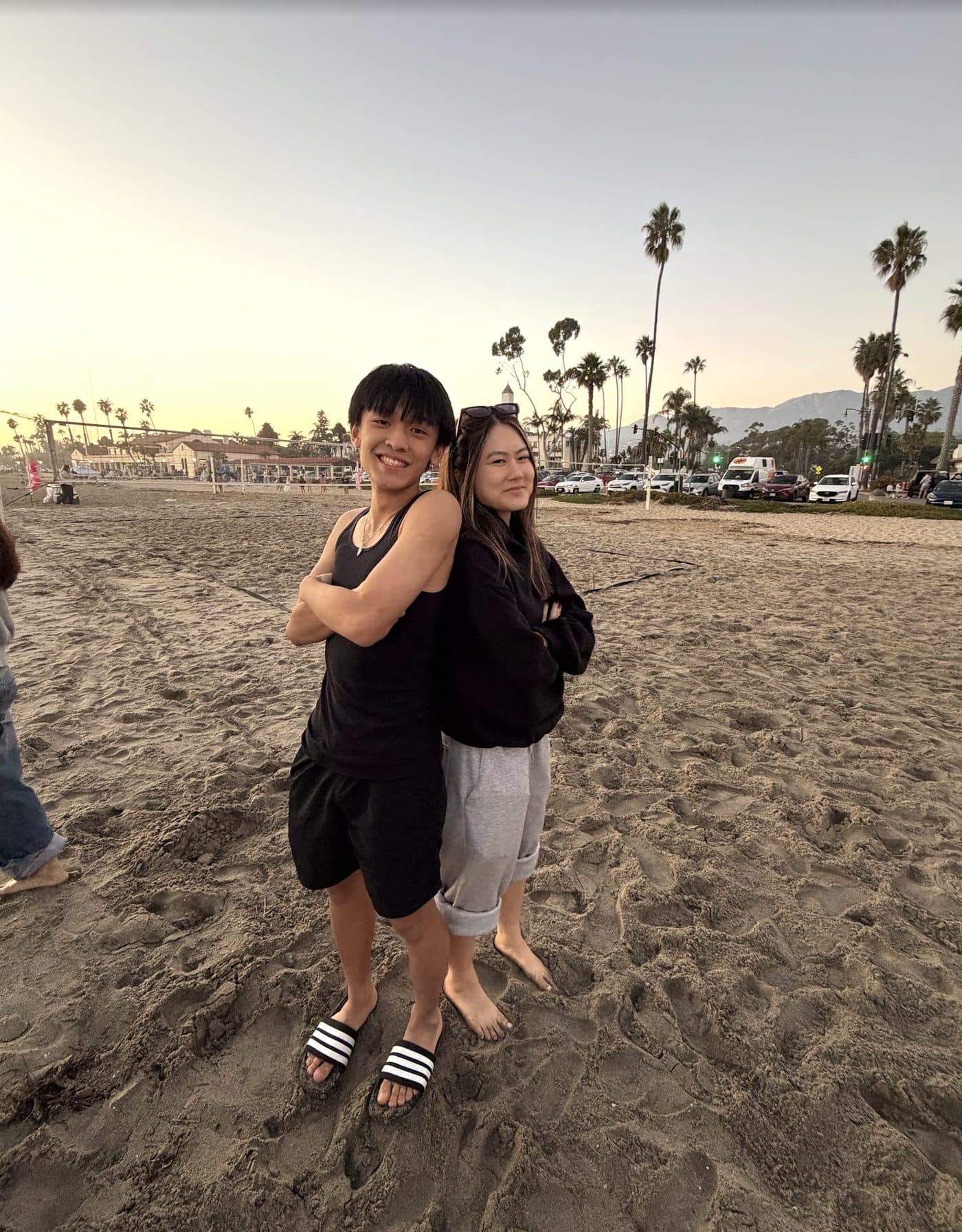 Two LA Hacks organizers hugging on the beach at sunset